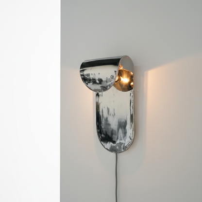 Modern wall lamp with metallic finish on a neutral background