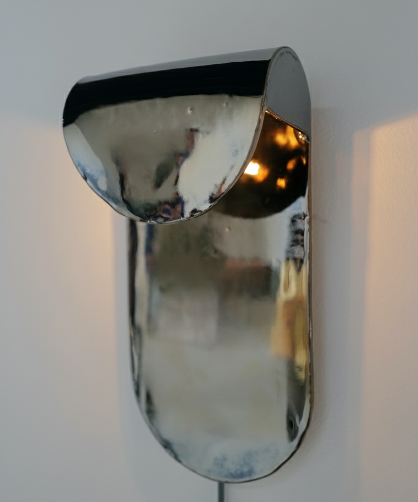 Chrome wall sconce on a white wall